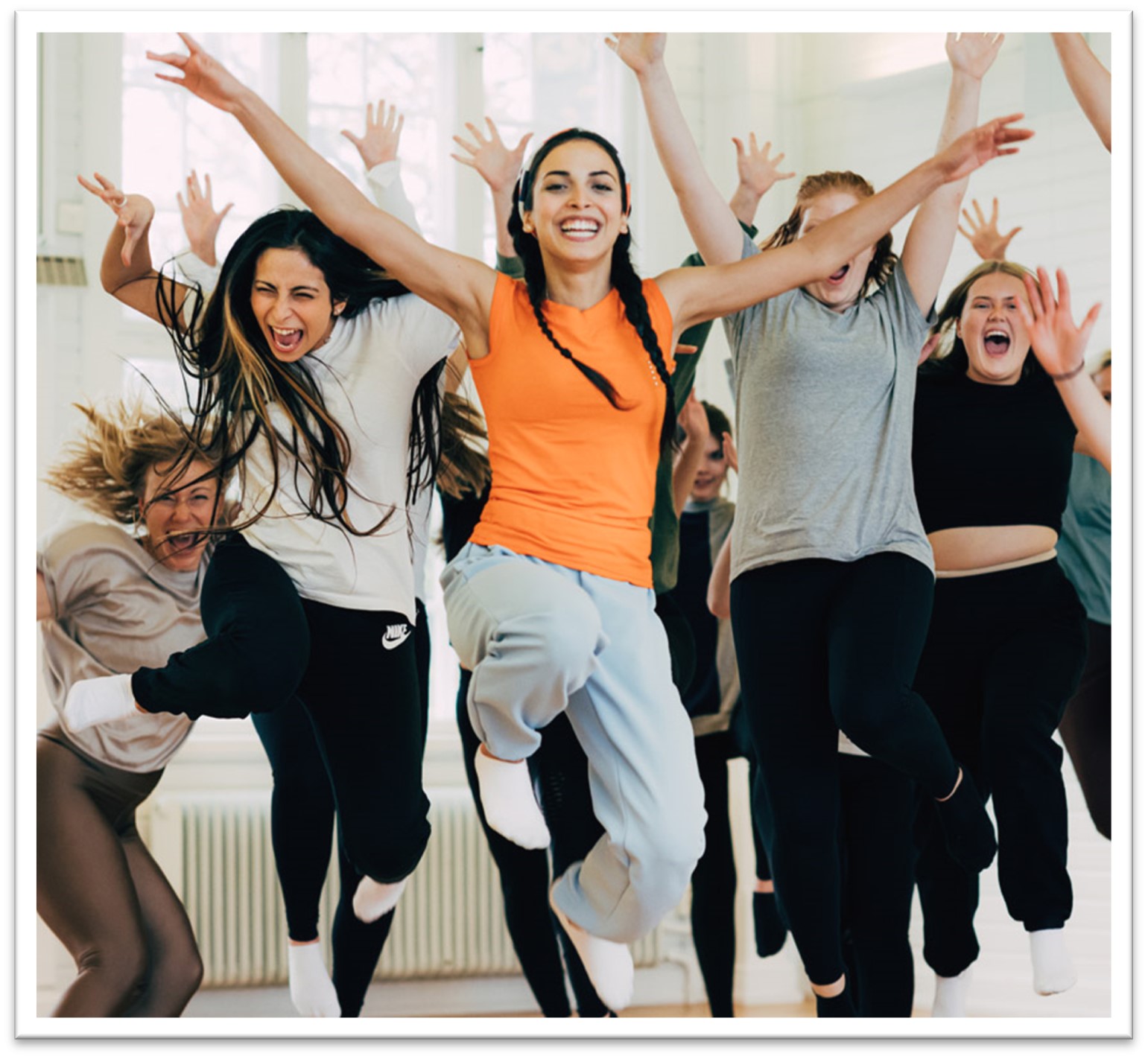 Ett gäng unga människor i en danslokal som hoppar i en modern dans.