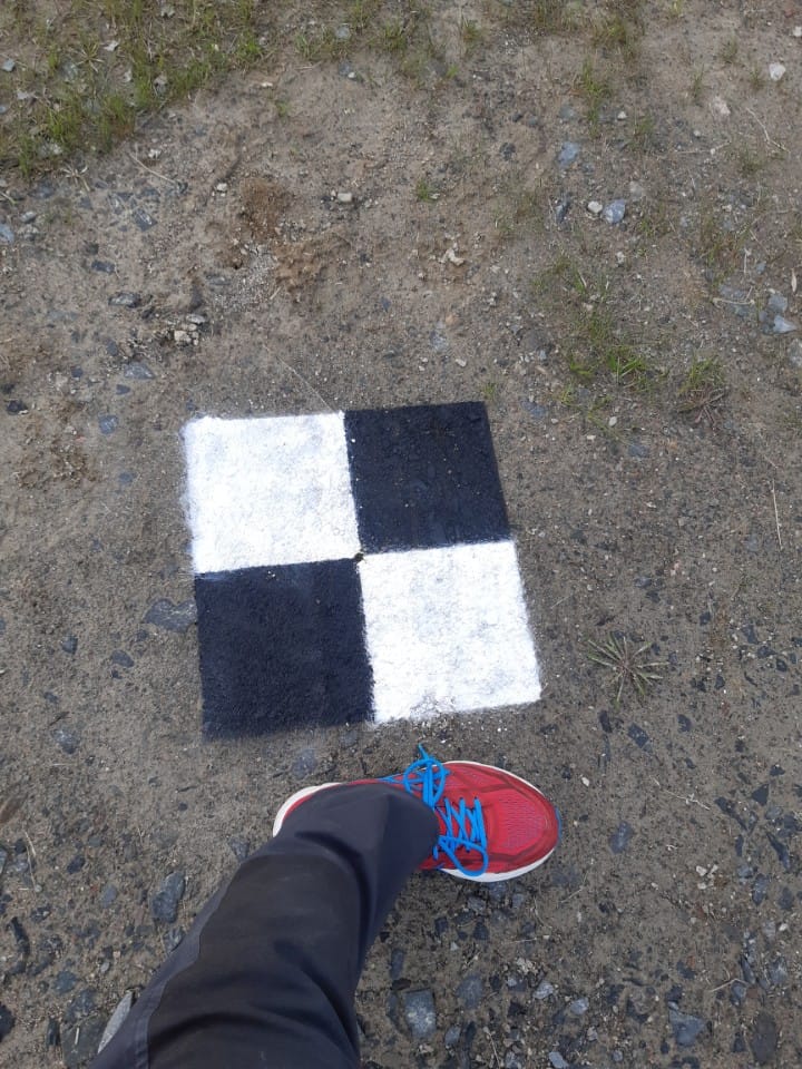Metrias stödpunkt på marken, en 2 gånger 2 stor schackbrädesliknande svartvit kvadrat, cirka 40 centimeter bred.