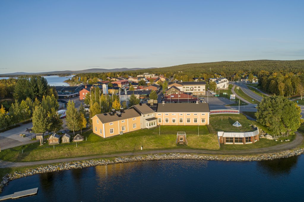 Silvermuseets baksida. Gula väggar, grönt gräs och blå himmel.