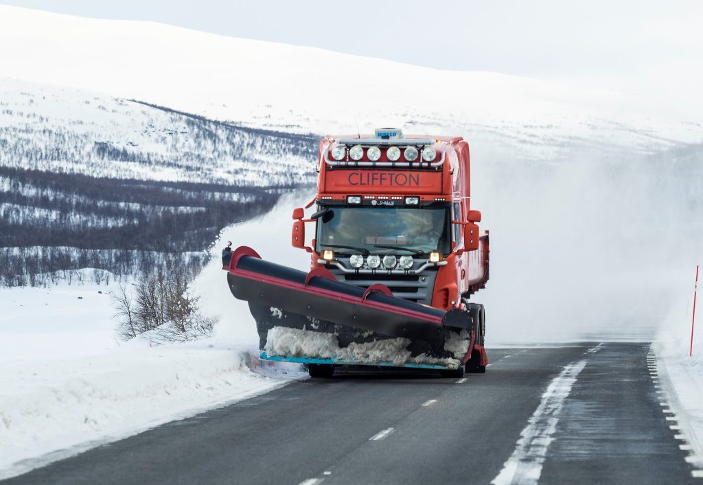 Plogbil som kör längs Silvervägen i ett vinterlandskap