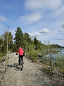 En persons som cyklar över en bro i vackert väder.