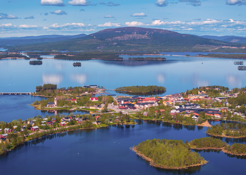 Fotovy över Arjeplogs samhälle en sommardag, med Galtis i bakgrunden.