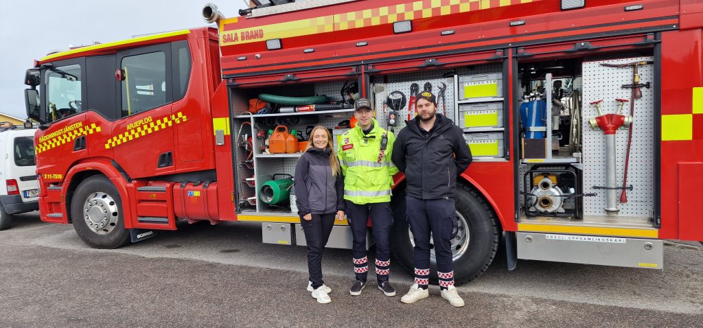 Nathalie Edholm, Patrik Holmner och Johan-Anton Arntzen framför Räddningstjänstens räddningsbil