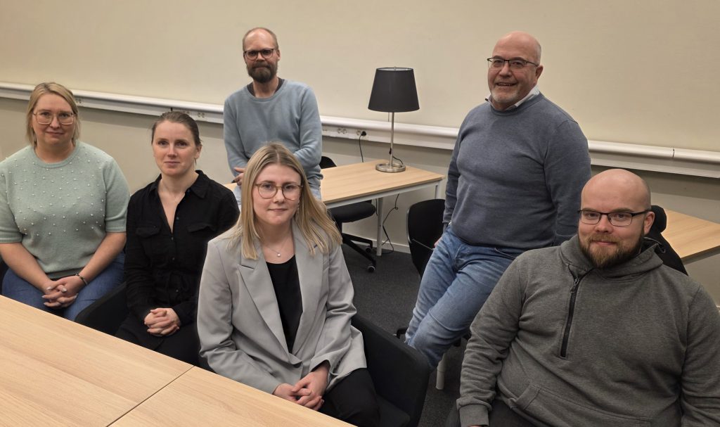 En bild på sex personer som sitter ner.