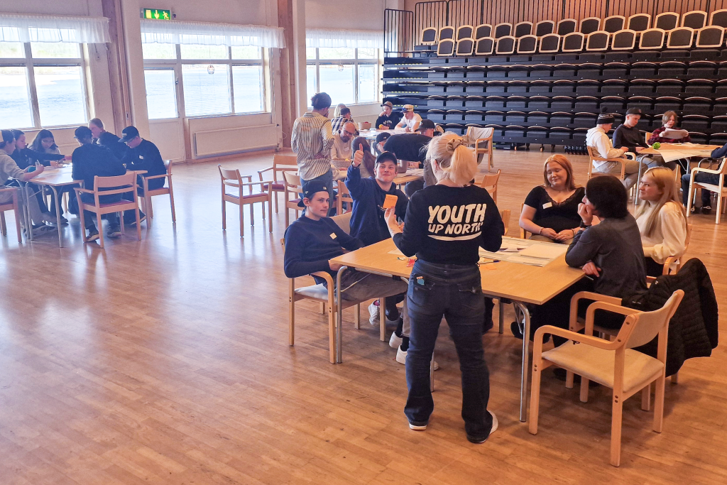 Ungdomar samlade kring bord i Medborgarhuset.,