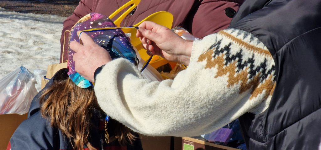 En medalj läggs runt ett barns huvud.