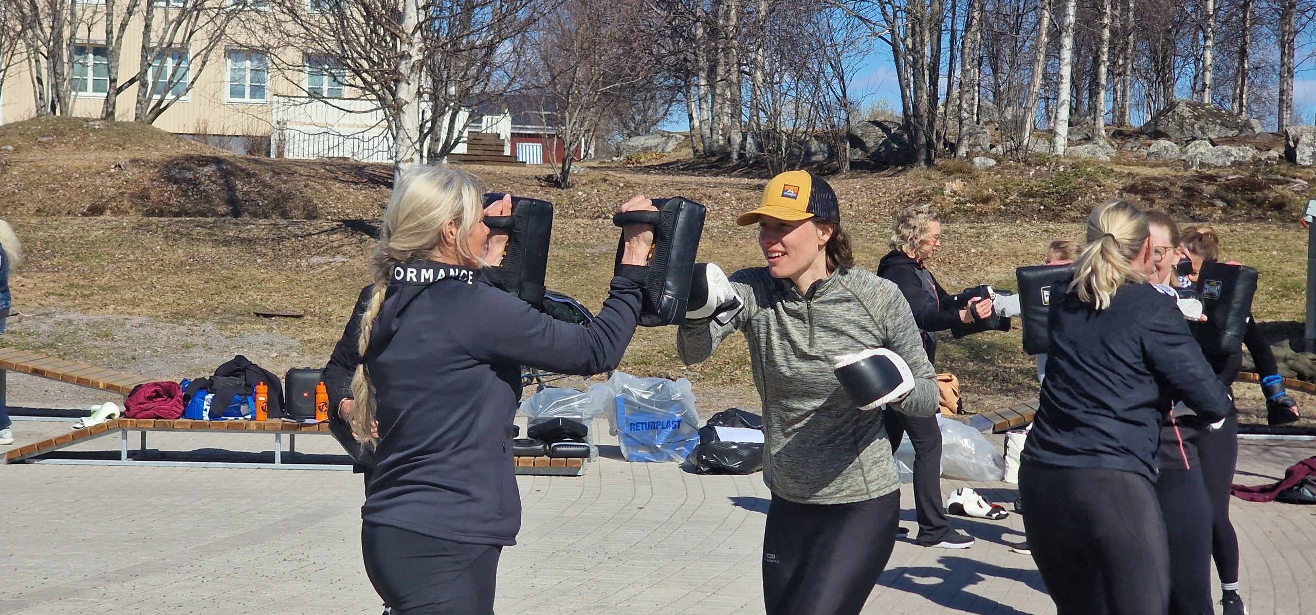 Lotta Lestander, Argentis, tillsammans med Hilde Pape, inflyttarlots på Arjeplogs kommun. kickboxar i vårsolen.