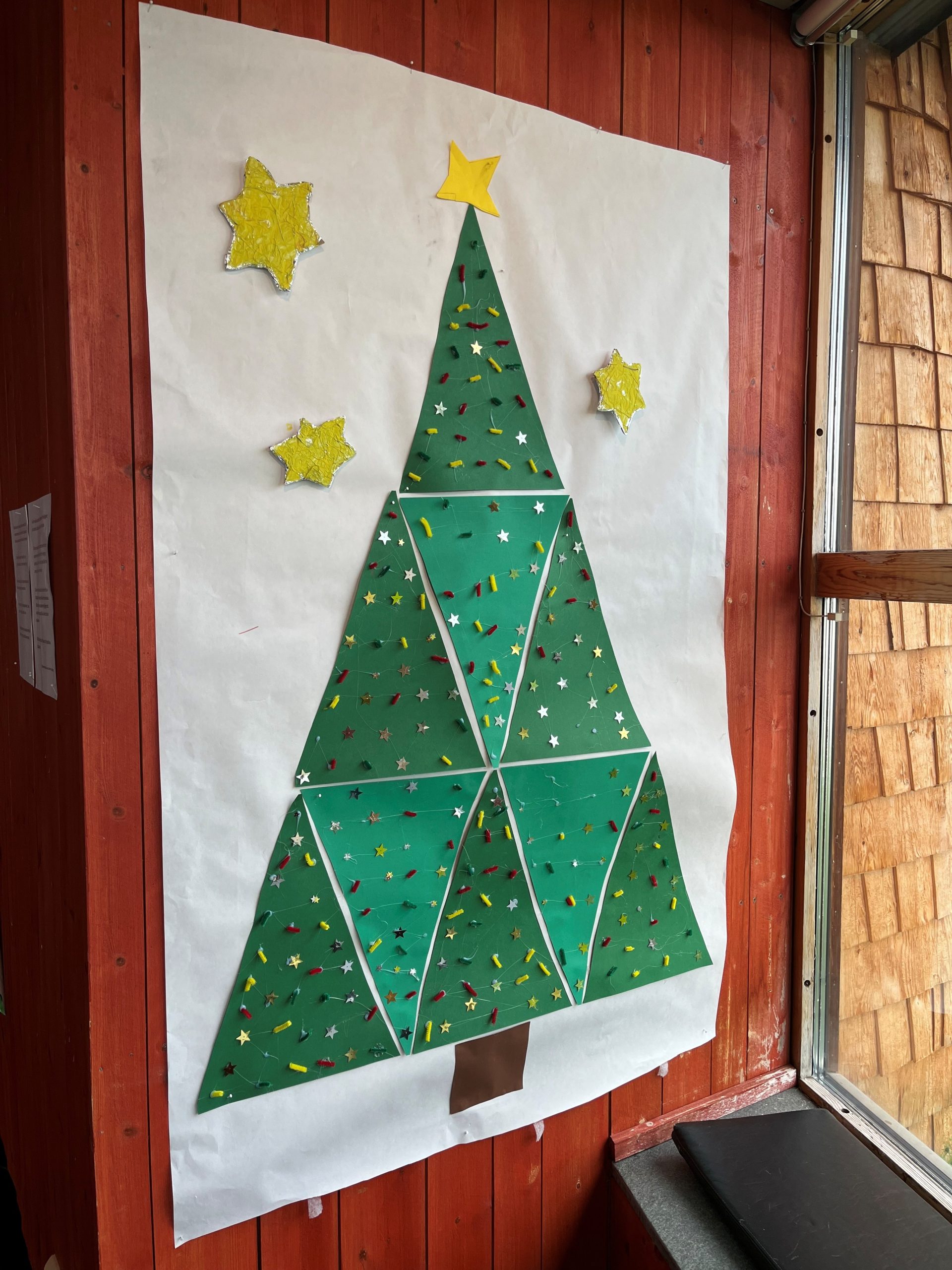 En stor geometrisk julgran på en vägg.