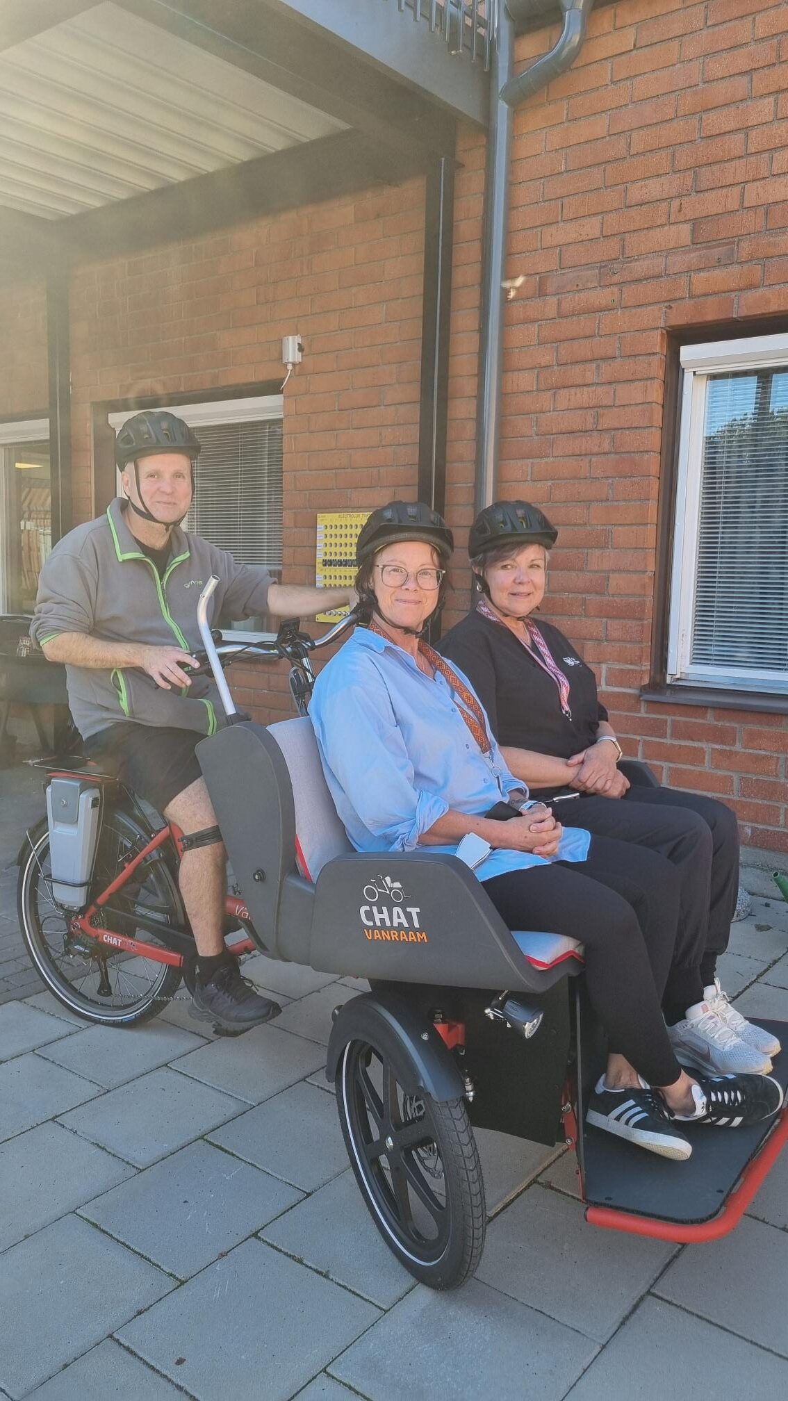 En person skjutsar två andra personer på ellådcykeln.