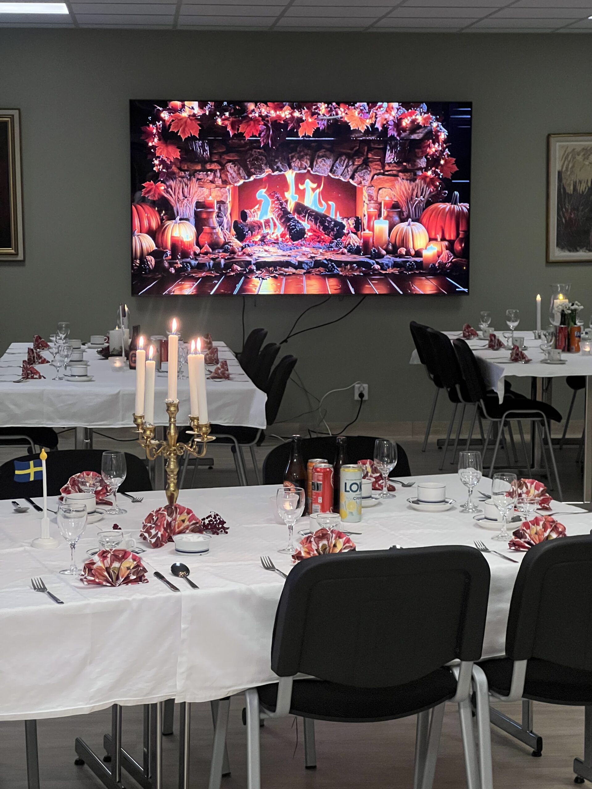 Ett fint dukat bord med en mysig tv-brasa i bakgrunden.